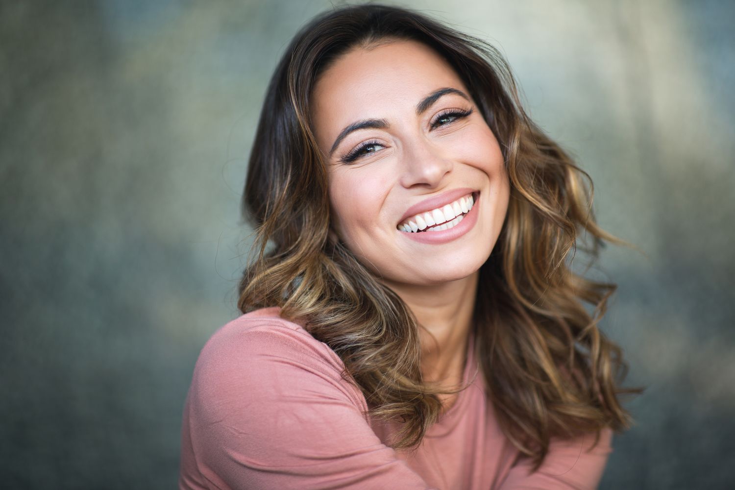Smiling woman with long, wavy hair.